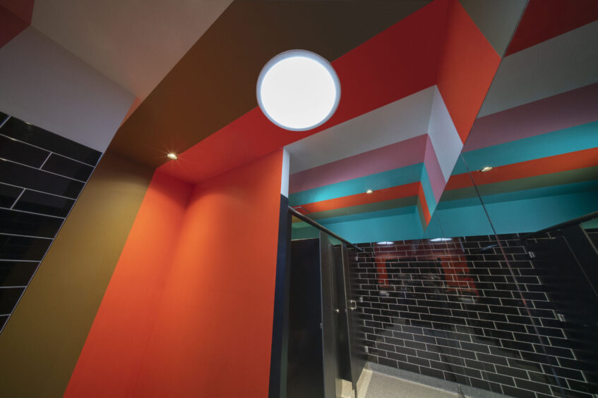 Explosive tones of reds, pinks and blues charge across the ceiling- colours which were chosen in consultation with the netball team.